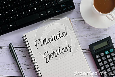 Top view of keyboard,pen,calculator,coffee, and notebook written with Financial Services. Stock Photo