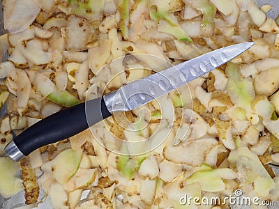 Top view of a knife lying on potato peelings Stock Photo