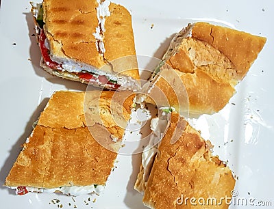 Top view of labneh sandwiches on a white plate. Creamy yoghurt spread on bread, with tomatoes and olives Stock Photo