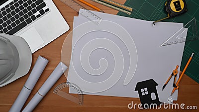 Top view laptop, blueprints, helmet and tools on wooden table. Engineer, Architect workspace Stock Photo