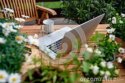 Top view of laptop on table on balcony in summer, outdoors office concept. Stock Photo