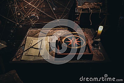 Top view of large compass and geometry tools and papers in a poorly lit room Stock Photo