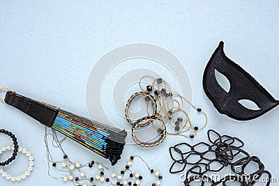 Top view of a lot of jewelry, black masquerade mask and fan Stock Photo