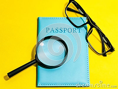 Top view magnifying glass with passport and eye glasses isolated on yellow background. Stock Photo