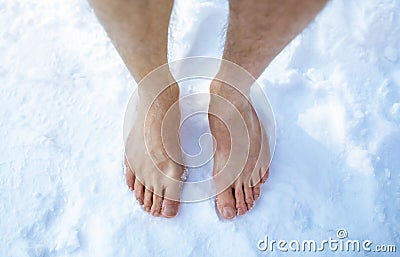 Top view of male feet standing on snow outdoors, cropped. Unrecognizable guy making cold exposure training Stock Photo