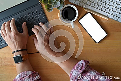 Top view man hand typing smart keyboard tablet on white table in studio workplace Stock Photo