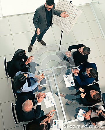 Top view. the Manager explains the new strategy to the working group. Stock Photo