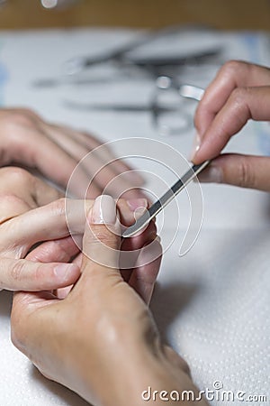 Top view manicurist polishing index finger for manicure in nail beauty salon. Step of manicure process. Manicure in beauty salon. Stock Photo