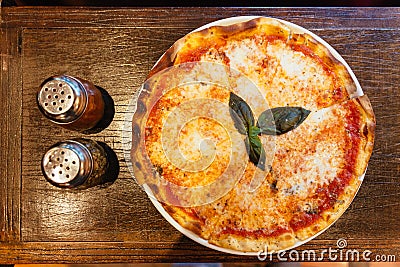 Top view of Margarita pizza topping with basil leaves served with oregano and chili powder Stock Photo