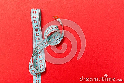 Top view of measuring tape on red background. Tailor and slim waist concept with emty space for your idea Stock Photo