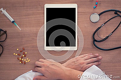 Top view on a medical desk with hands of the doctor. Blank on the digital tablet Stock Photo