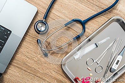 Top view of medical instruments and laptop. Syringe, stethoscope, clamp, thermometer on a clay Stock Photo