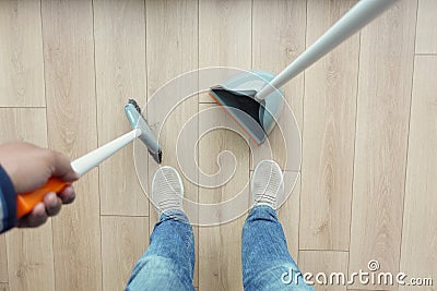top view of men suing floor dust with dust pan Stock Photo