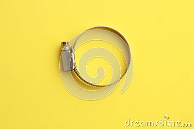 Top view of a metal plumber clamp on a bright yellow background Stock Photo