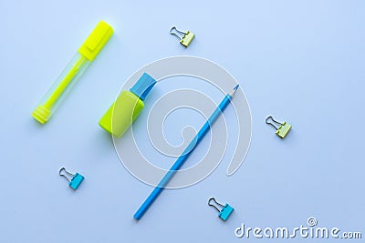 Top view of mixed stationery in yellow and blue colours: clips, correction fluid, pencil and marker pen on white background. Conce Stock Photo