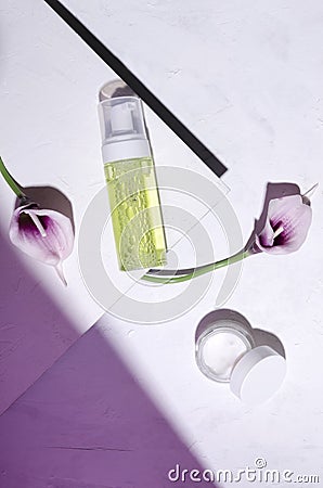 Top view of moisturizig products, calla flowers on the white surface, puprle light Stock Photo