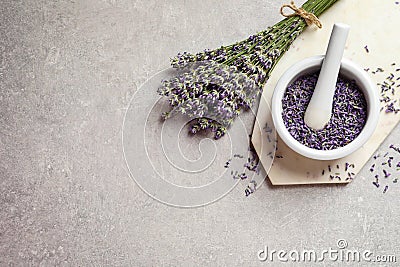 Top view of mortar and pestle with lavender flowers on stone background, space for text. Natural cosmetic Stock Photo