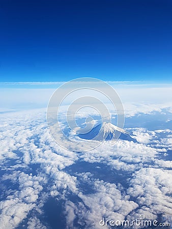 Top view - Mt Fuji from sky view on window seat of plane. Blue sky and many clouds Stock Photo