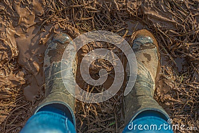 Close Up of Wellington Boots in a Muddy Field Viewed from Above Stock Photo