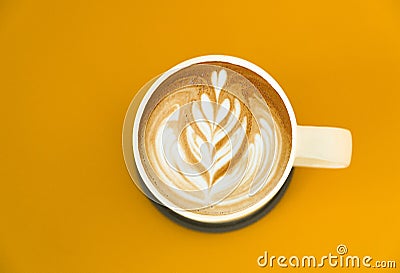 view of a mug of latte art coffee isolted on yellow background Stock Photo