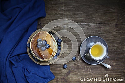 Top view of national dish pancakes, pancakes, pita with blueberries, linen napkin, poured with honey, concept of traditional Stock Photo