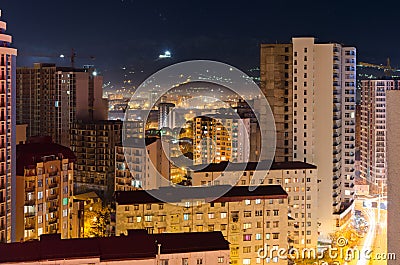 Top view of the night street of the sleeping area city of Batumi with high-rise buildings, light from home windows. Stock Photo