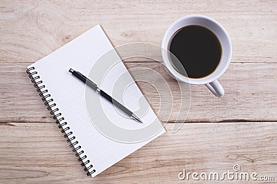 Top view Note book with pen and a cup of coffee on wood table for Business Stock Photo