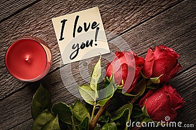 Top view note with the words I love you! and red roses with aroma candle on a wooden background: concept of assurance of love Stock Photo