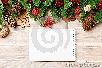 Top view of notebook, Christmas toys, decorations and fir tree branches on wooden background. New Year holiday concept Stock Photo