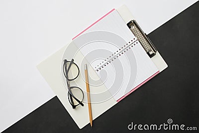 Top view notebooks pencils and glasses placed on a black and white desk In the office and have copy space. Stock Photo