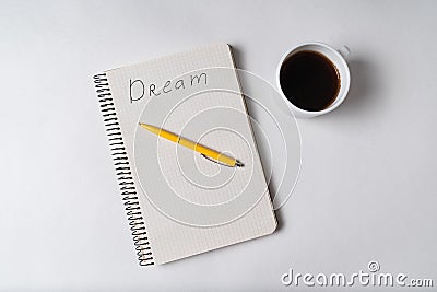 Top view of notepad with inscription Dream. Pen and cup of coffee. Motivational note Stock Photo