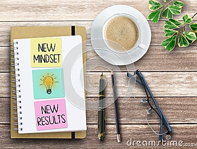 Top view notepad with New Mindset New Results text on wood table background Stock Photo