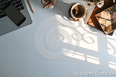 Top view office desk with computer, coffee mobile phone and office supply on table and morning windows light Stock Photo