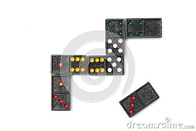 Top view old black color dominoes with colorful dot pieces on white floor background. Stock Photo