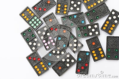 Top view old black color dominoes with colorful dot pieces on white floor background. Stock Photo