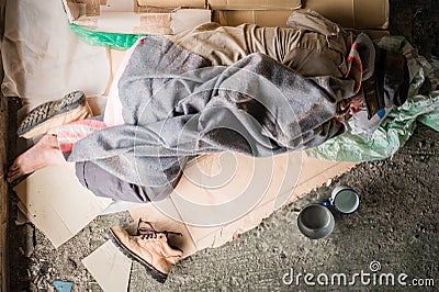 Top view of old homeless man wearing sweater and blanket sleeping on cardboard seeking help because hungry and food beggar from Stock Photo