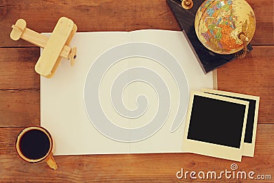 Top view of open blank notebook and and polaroid blank photography frames next to cup of coffee over wooden table. ready for Stock Photo