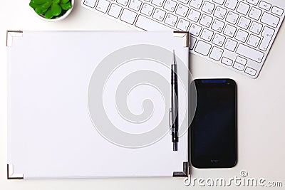 Top view open notebook, pencil and plant potted on white desk background Stock Photo