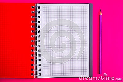 Top view of open spiral blank notebook with pencil on red desk background Stock Photo