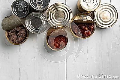 Top view of opened cans with fish conserves on wooden background Stock Photo