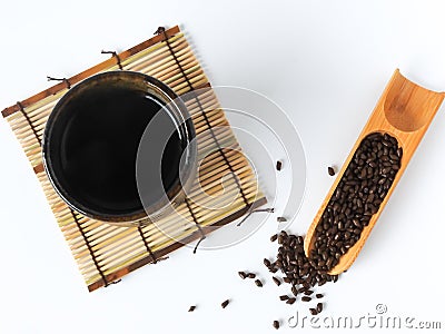 Top view of organic fetid cassia seed also called ketsumei-shi on wooden spoon isolated on a white background. Stock Photo