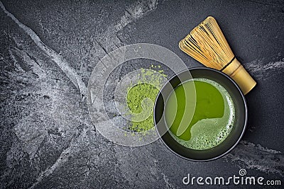 Top view on organic green matcha tea in black ceramic cup with bamboo whisk Stock Photo