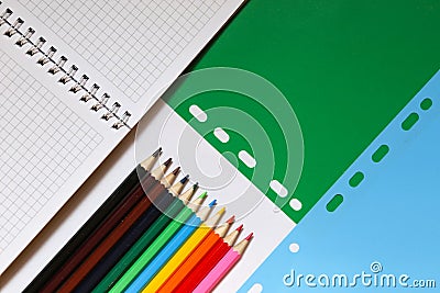 Top view over a notebooks, pencils, on a green blue background. Back to school concept Stock Photo