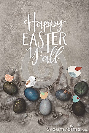 top view of painted easter eggs with feathers on concrete surface with birds and Happy Easter you Stock Photo
