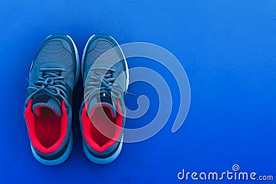 Top view pair of blue and red running sport shoes isolated on dark blue background with copy space. Healthy lifestyle and exercise Stock Photo