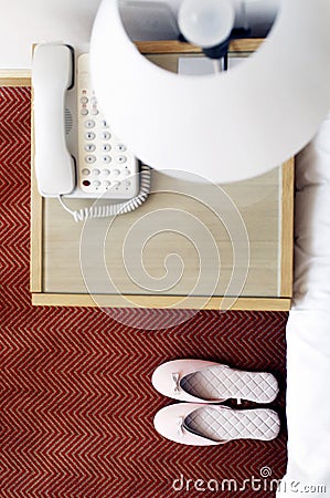 Top view of a pair of pink shoes beside the bed. Conceptual image shot Stock Photo