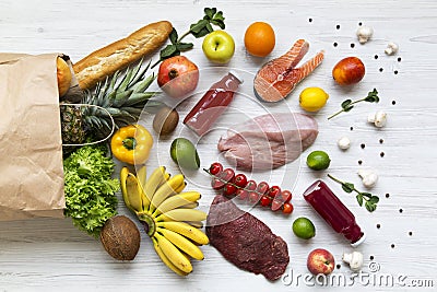 Top view, paper bag of different healthy products over white wooden background. Stock Photo