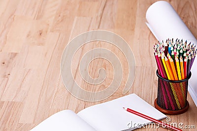 Top view of paper roll and school supplies on the wood background. Pencils and notebook. Stock Photo