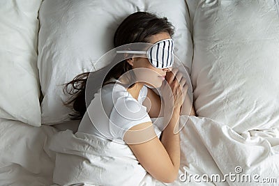 Top view peaceful young female wearing mask sleeping on side Stock Photo