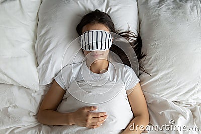 Top view peaceful young woman wearing mask sleeping in bed Stock Photo